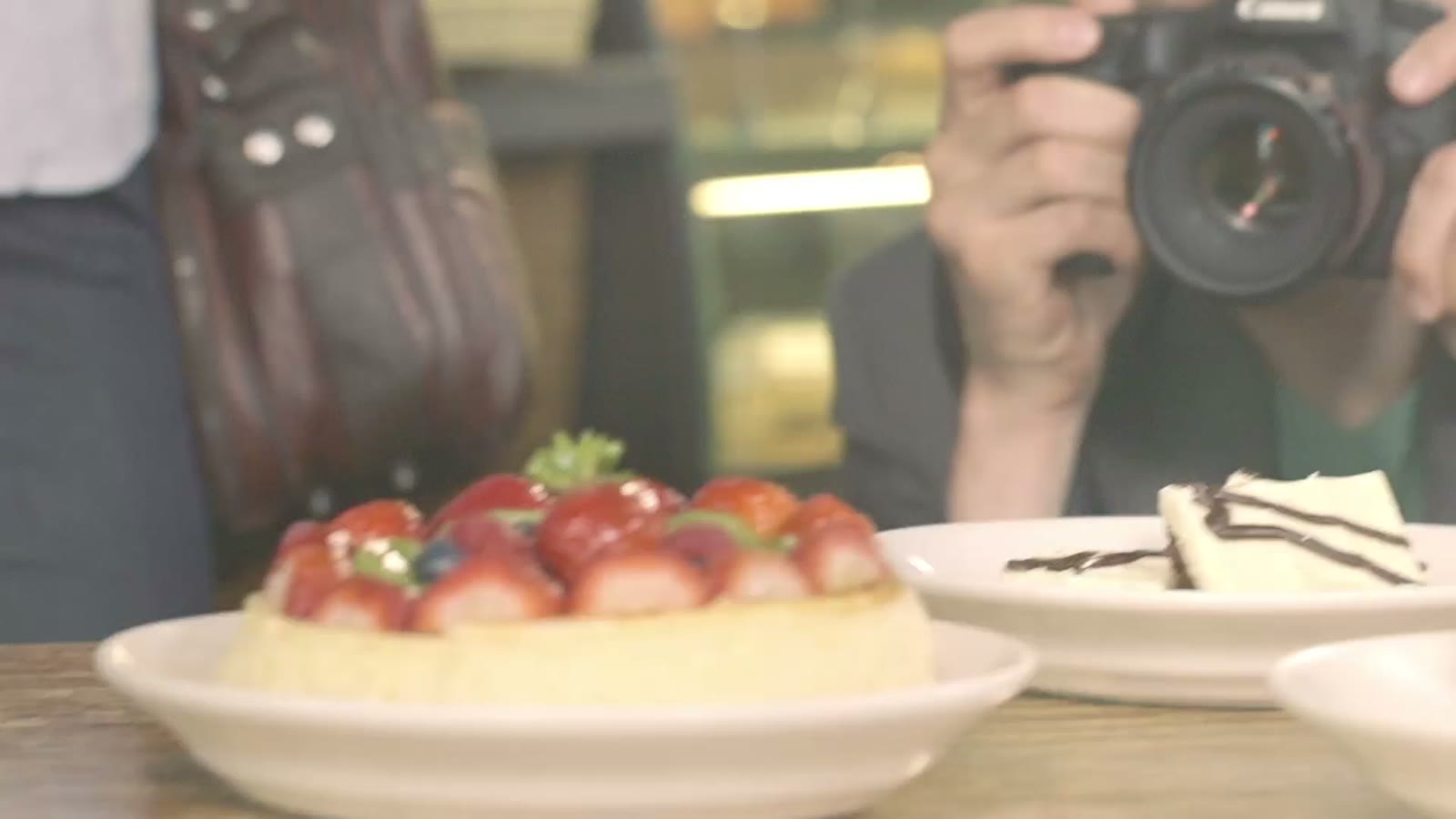 A photographer shooting desserts in a cafe