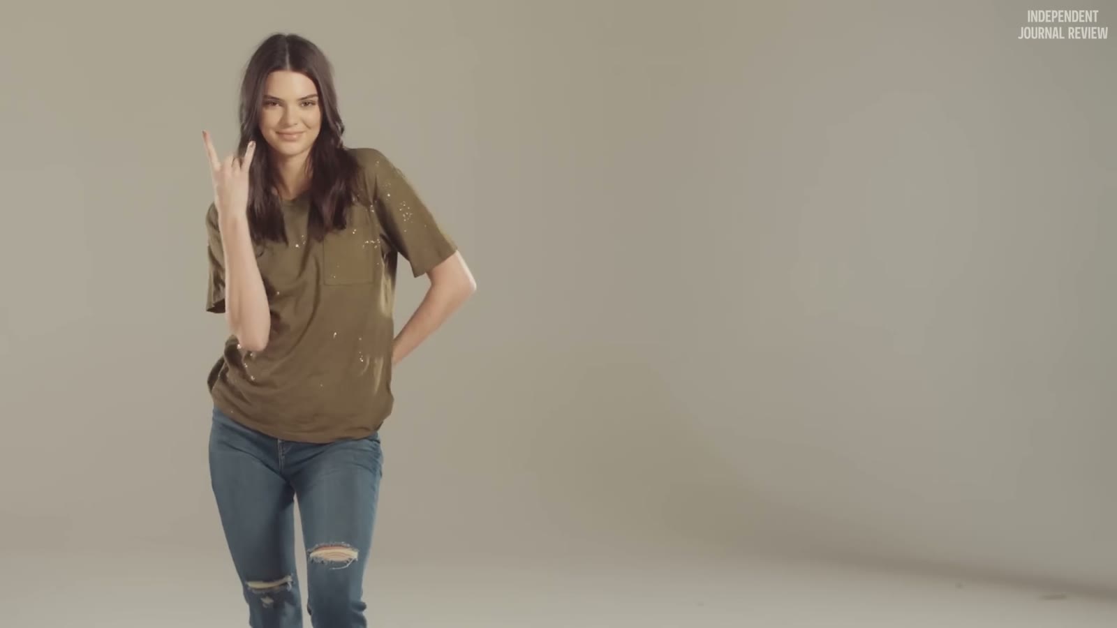 Kendall in a grunge tee throwing a rock sign